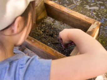 Mijnen voor kinderen – Kind zeeft om edelstenen te vinden. Mijnen voor kinderen – Kind zeeft om edelstenen te vinden.