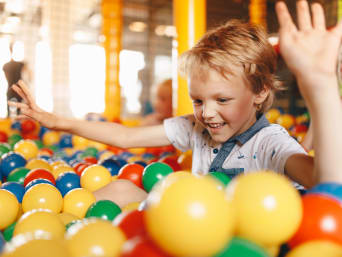 Binnenspeeltuin - kind speelt in een ballenbak. Binnenspeeltuin - kind speelt in een ballenbak.