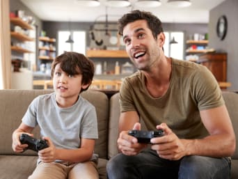 PEGI betekenis – Vader en zoon spelen samen een geschikte videogame voor kinderen. PEGI betekenis – Vader en zoon spelen samen een geschikte videogame voor kinderen.