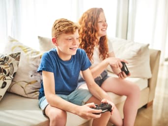 Spielekonsole Kinder – Geschwister spielen gemeinsam ein Multiplayer-Spiel Spielekonsole Kinder – Geschwister spielen gemeinsam ein Multiplayer-Spiel
