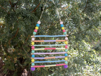 Kreatives Basteln für den Garten: Fertiges Windspiel hängt an Baum. Kreatives Basteln für den Garten: Fertiges Windspiel hängt an Baum.