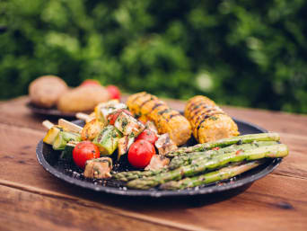 Vegetarian barbecue recipes: vegetable kebabs, corn on the cob and green asparagus on a plate.   Vegetarian barbecue recipes: vegetable kebabs, corn on the cob and green asparagus on a plate.