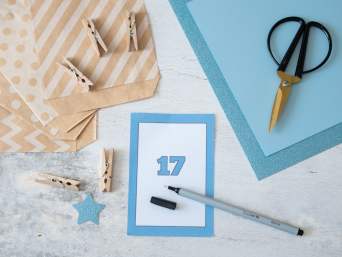 DIY-cadeau 18 jaar: een van de 18 kaarten ligt op tafel met knutselspullen. DIY-cadeau 18 jaar: een van de 18 kaarten ligt op tafel met knutselspullen.