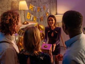 Een verjaardagsfeest organiseren: een jarige vrouw krijgt een cadeau van haar vrienden. Een verjaardagsfeest organiseren: een jarige vrouw krijgt een cadeau van haar vrienden.