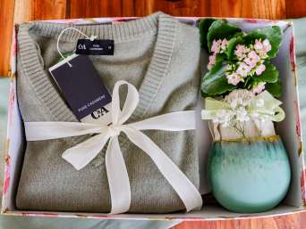 Verjaardagscadeau moeder: een liefdevol verpakte cadeaubox ligt op een tafel. Verjaardagscadeau moeder: een liefdevol verpakte cadeaubox ligt op een tafel.