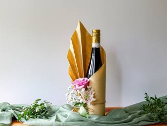 Cadeau voor papa: een liefdevol ingepakte wijnfles staat op tafel. Cadeau voor papa: een liefdevol ingepakte wijnfles staat op tafel.