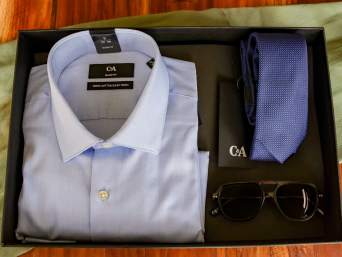Cadeau voor papa: cadeauverpakking met overhemd, stropdas en zonnebril ligt op tafel. Cadeau voor papa: cadeauverpakking met overhemd, stropdas en zonnebril ligt op tafel.