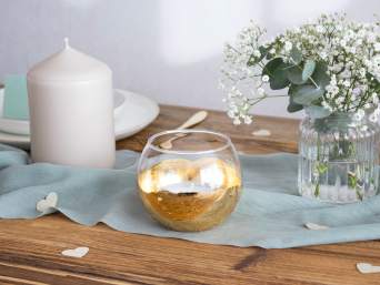 Tischschmuck für Goldene Hochzeit – Goldener Teelichthalter auf dem Tisch.