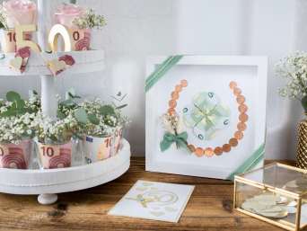 Selbst gemachte Geschenke zur Goldenen Hochzeit – Verschiedene Geschenke auf einem Tisch.