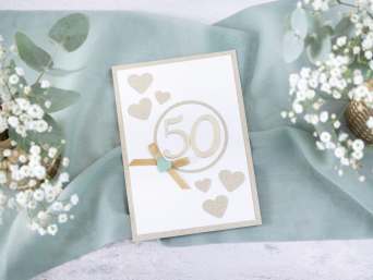 Glückwunschkarte zur Goldenen Hochzeit selbst gestalten – Moderne Karte mit Herzen und einer Schleife.