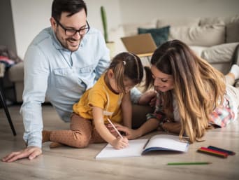 Schulstart erleichtern – Kind zeichnet zusammen mit den Eltern mit Stiften. Schulstart erleichtern – Kind zeichnet zusammen mit den Eltern mit Stiften.