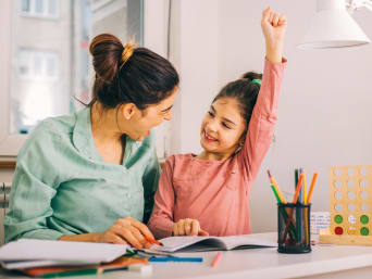 Huiswerktips voor ouders - moeder en dochter zijn blij met het gemaakte huiswerk. Huiswerktips voor ouders - moeder en dochter zijn blij met het gemaakte huiswerk.