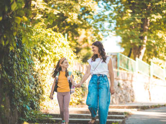 Erster Schultag nach den Sommerferien – Mutter und Tochter laufen zur Schule. Erster Schultag nach den Sommerferien – Mutter und Tochter laufen zur Schule.