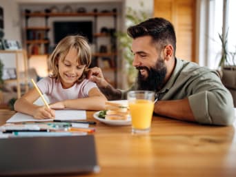 Motivatie om te leren - vader prijst zijn dochter terwijl ze leert.  Motivatie om te leren - vader prijst zijn dochter terwijl ze leert.