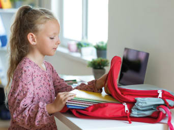 Schulsachen organisieren – Mädchen packt ihre Schultasche. Schulsachen organisieren – Mädchen packt ihre Schultasche.