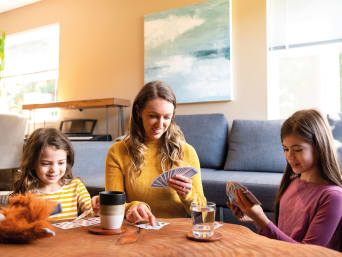 Beginnen met school na de vakantie - moeder speelt kaart met haar dochters. Beginnen met school na de vakantie - moeder speelt kaart met haar dochters.