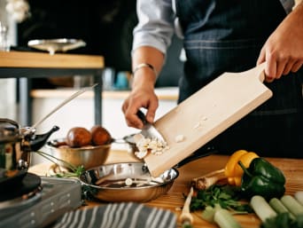 Kochen lernen – Hobbykoch gibt geschnittene Zutaten in eine Pfanne. Kochen lernen – Hobbykoch gibt geschnittene Zutaten in eine Pfanne.