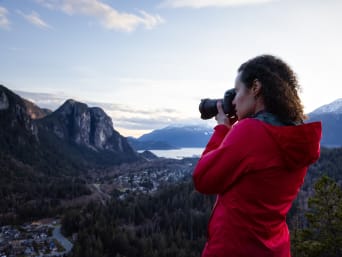 Landscape photography – a woman taking photos of a mountain landscape. Landscape photography – a woman taking photos of a mountain landscape.
