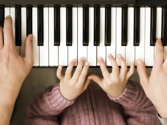 Musikinstrumente Kinder – Eltern spielen gemeinsam mit dem Kind Klavier. Musikinstrumente Kinder – Eltern spielen gemeinsam mit dem Kind Klavier.