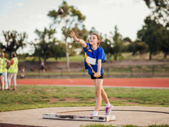 Leichtathletik Übungen für Kinder – Mädchen beim Kugelstoßen. Leichtathletik Übungen für Kinder – Mädchen beim Kugelstoßen.