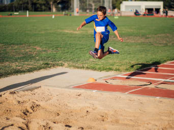 Kinderleichtathletik – Bub beim Weitsprung. Kinderleichtathletik – Bub beim Weitsprung.