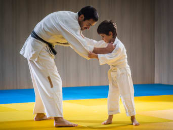 Kampfsport für Kinder: Judo-Trainer und -schüler üben einen Judowurf. Kampfsport für Kinder: Judo-Trainer und -schüler üben einen Judowurf.
