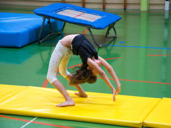 Bodenturnen für Kinder: Mädchen bei einem Handstützüberschlag rückwärts. Bodenturnen für Kinder: Mädchen bei einem Handstützüberschlag rückwärts.