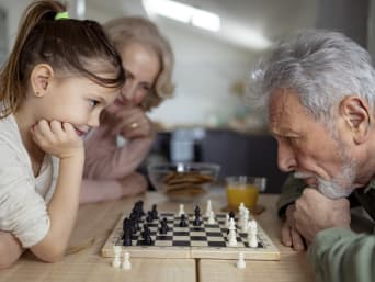 Schach lernen Kinder – Mädchen spielt gegen ihren Großvater. Schach lernen Kinder – Mädchen spielt gegen ihren Großvater.