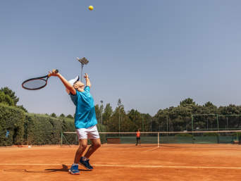 Tennis Kinder: Ein Bub spielt Tennis auf einem Tennisplatz und macht einen Aufschlag. Tennis Kinder: Ein Bub spielt Tennis auf einem Tennisplatz und macht einen Aufschlag.