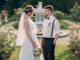 Vintage style suits with braces: a bride and groom in a beautiful garden. Vintage style suits with braces: a bride and groom in a beautiful garden.