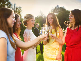 Women’s wedding guest dresses: a group of women toasting with the bride. Women’s wedding guest dresses: a group of women toasting with the bride.