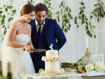Trouwerij kosten per gast voor catering: bruidspaar snijdt de taart aan.  Trouwerij kosten per gast voor catering: bruidspaar snijdt de taart aan.