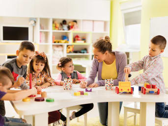 Kindergarten – Gruppe malt und spielt am Tisch. Kindergarten – Gruppe malt und spielt am Tisch.