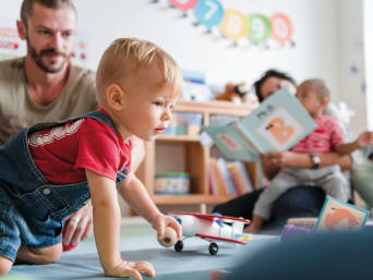 Kindergarten Eingewöhnung – Sohn spielt im Kindergarten und sein Vater schaut zu. Kindergarten Eingewöhnung – Sohn spielt im Kindergarten und sein Vater schaut zu.