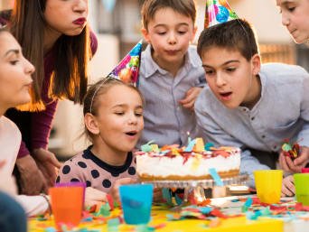 Kindergeburtstag planen: Mädchen pustet Kerze von Kindergeburtstagstorte aus. Kindergeburtstag planen: Mädchen pustet Kerze von Kindergeburtstagstorte aus.