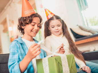 Children's gift from 6 years old. Boy opening his birthday present with his sister. Children's gift from 6 years old. Boy opening his birthday present with his sister.