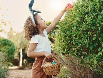 Easter gifts for children: a young girl collecting Easter eggs in the garden. Easter gifts for children: a young girl collecting Easter eggs in the garden.