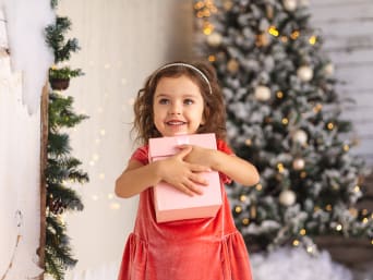 Christmas gifts for girls – a young girl holding her Christmas present. Christmas gifts for girls – a young girl holding her Christmas present.
