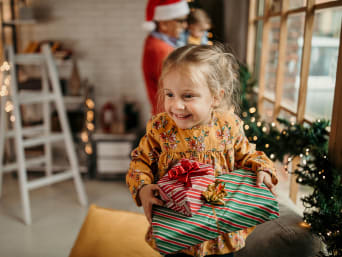 Christmas presents for children – a little girl is excited to open her Christmas presents. Christmas presents for children – a little girl is excited to open her Christmas presents.