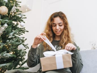 Christmas presents for teenagers – a teenage girl unwrapping her Christmas present. Christmas presents for teenagers – a teenage girl unwrapping her Christmas present.