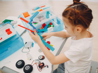 Geschenk für 8-jährige Mädchen und Jungs: Kleines Mädchen baut mit einem Set einen Roboter zusammen. Geschenk für 8-jährige Mädchen und Jungs: Kleines Mädchen baut mit einem Set einen Roboter zusammen.