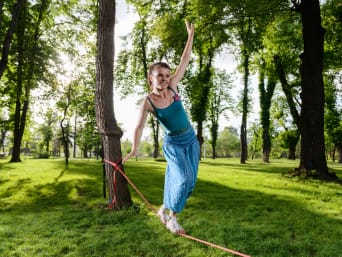 Dárky pro dvanáctileté: mladá slečna chodí v parku po slacklině. Dárky pro dvanáctileté: mladá slečna chodí v parku po slacklině.