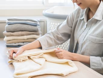 Folding a jumper: a woman folding a jumper. Folding a jumper: a woman folding a jumper.