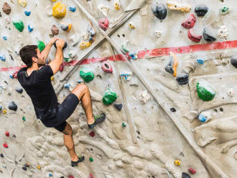 Bouldern – Junger Mann löst ein Boulderproblem. Bouldern – Junger Mann löst ein Boulderproblem.