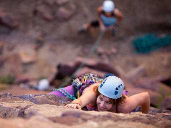 Klettergarten – Frau beim Outdoor-Klettern mit Kletterhelm Klettergarten – Frau beim Outdoor-Klettern mit Kletterhelm