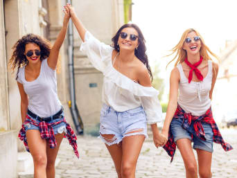 Shorts guide: three women wearing shorts walking through a city. Shorts guide: three women wearing shorts walking through a city.