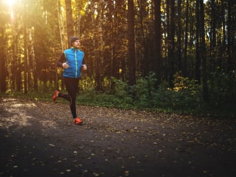 Running in winter: a man jogging on a forest path. Running in winter: a man jogging on a forest path.