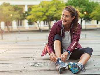 Beginner running: a woman tying her shoelaces. Beginner running: a woman tying her shoelaces.