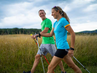 Nordic walking for beginners: a woman learning the Nordic walking technique from her trainer. Nordic walking for beginners: a woman learning the Nordic walking technique from her trainer.
