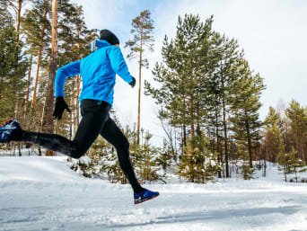 Jogging in winter: a man running on a snow-covered trail. Jogging in winter: a man running on a snow-covered trail.